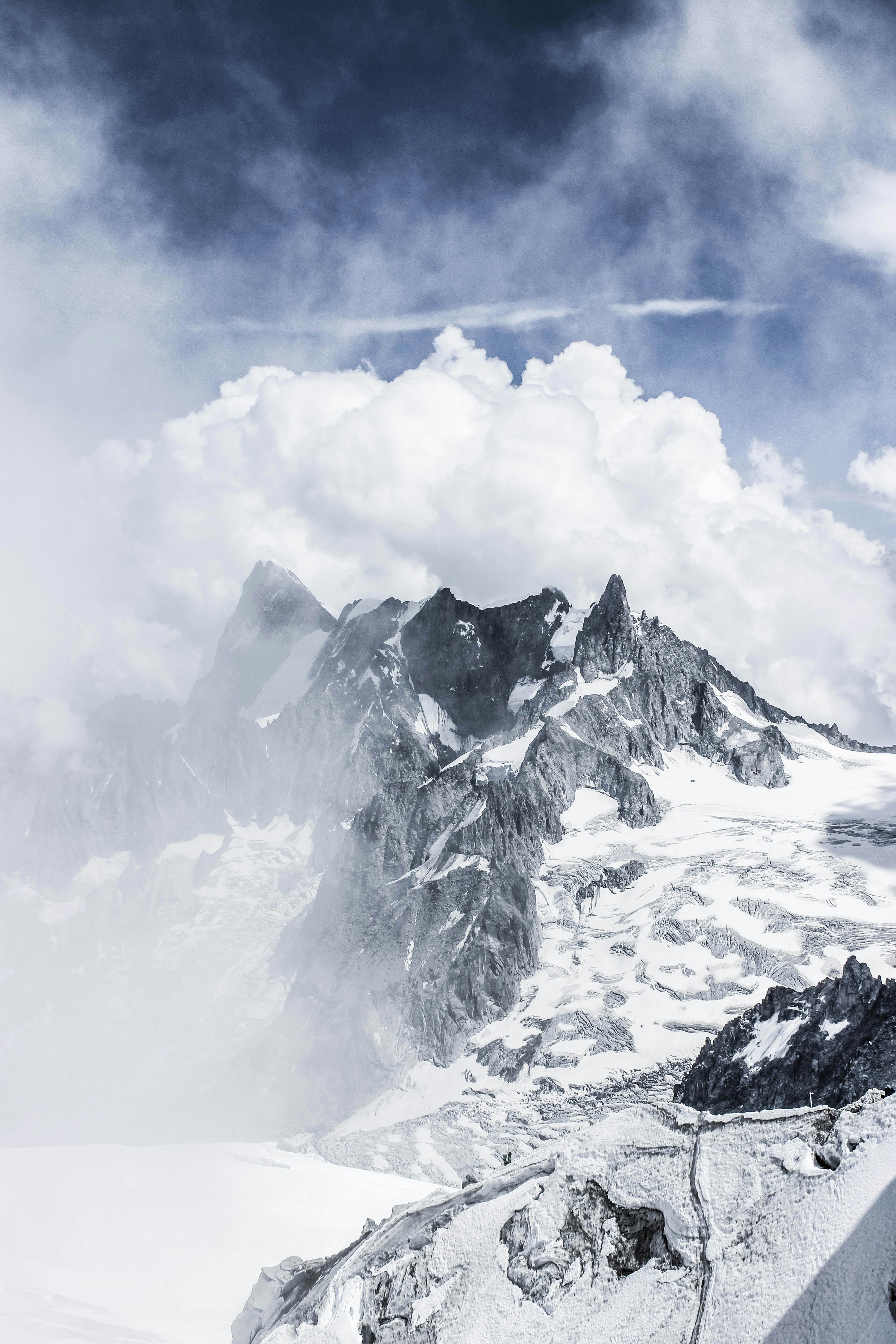 Dramatic mountain peaks covered with snow in fog · Free Stock Photo