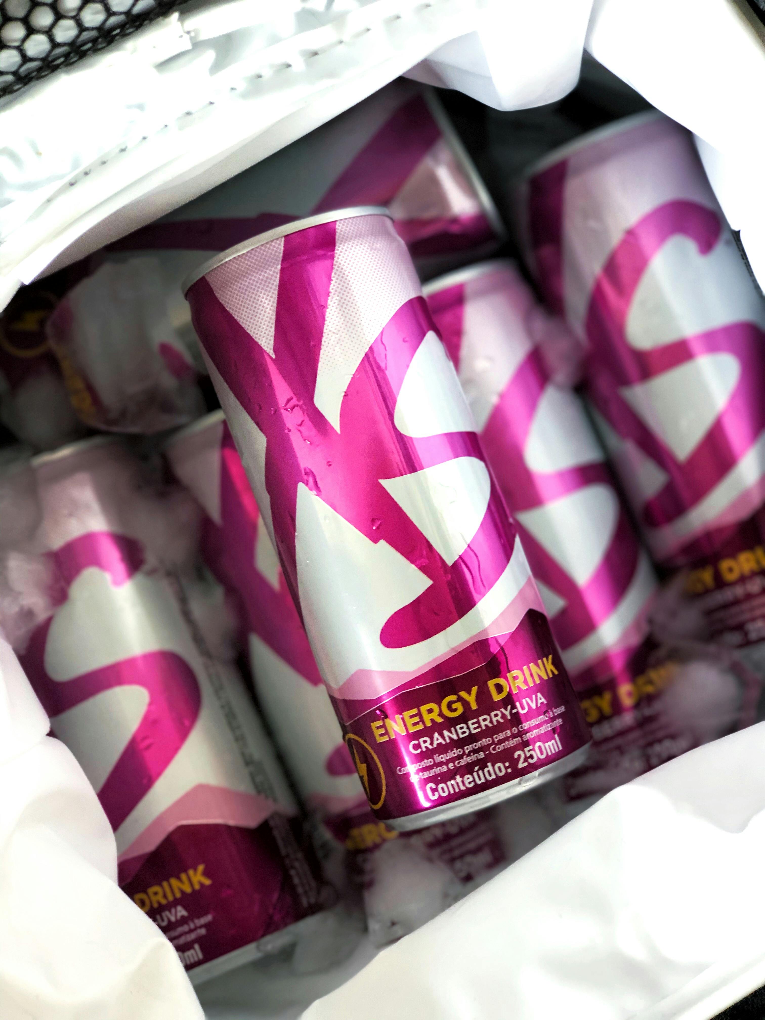 Cranberry-flavored energy drink cans chilled in ice, perfect for a refreshing boost.