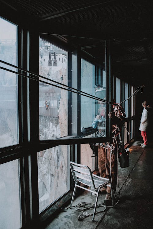 Industrial abseiler standing near window on attic