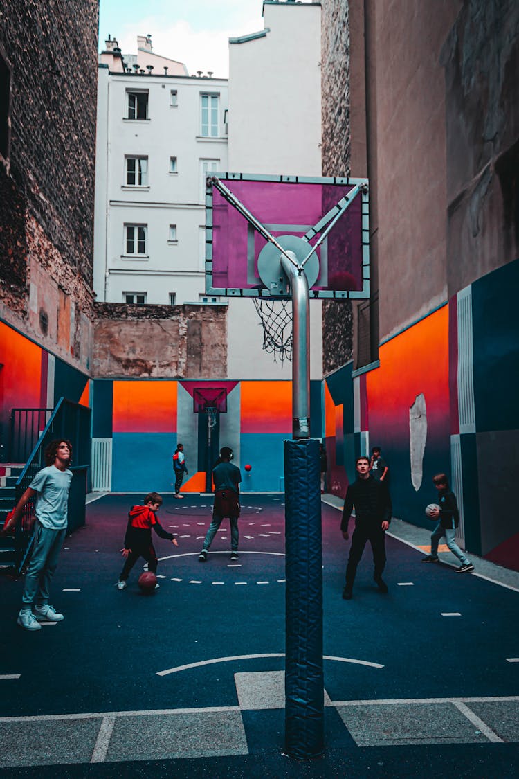 Teenagers Playing Basketball On Street Court