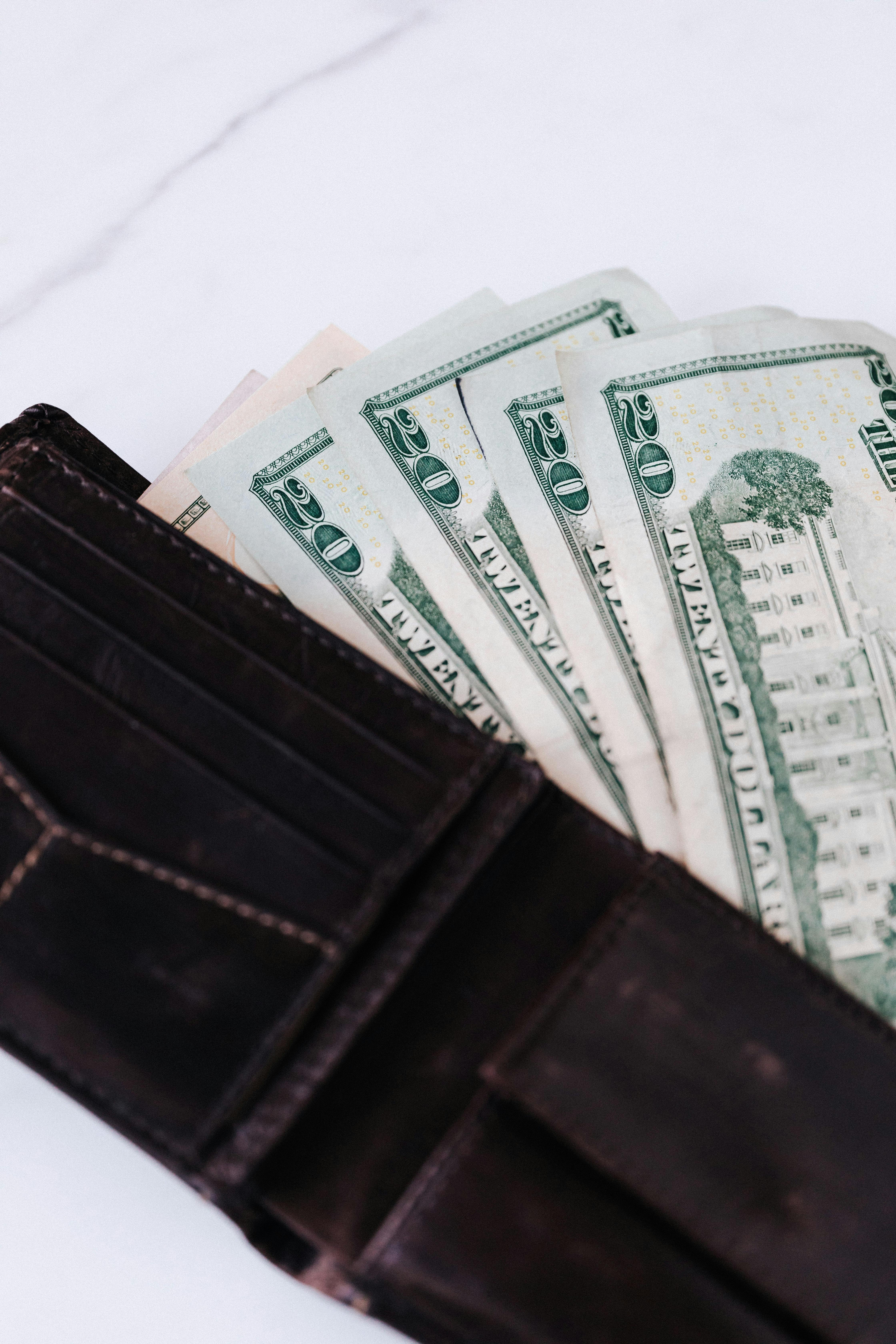 black wallet with dollar banknotes