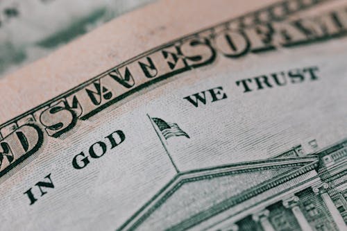 Free Closeup of ten dollar with inscription In God We Trust bill placed on table with different money Stock Photo