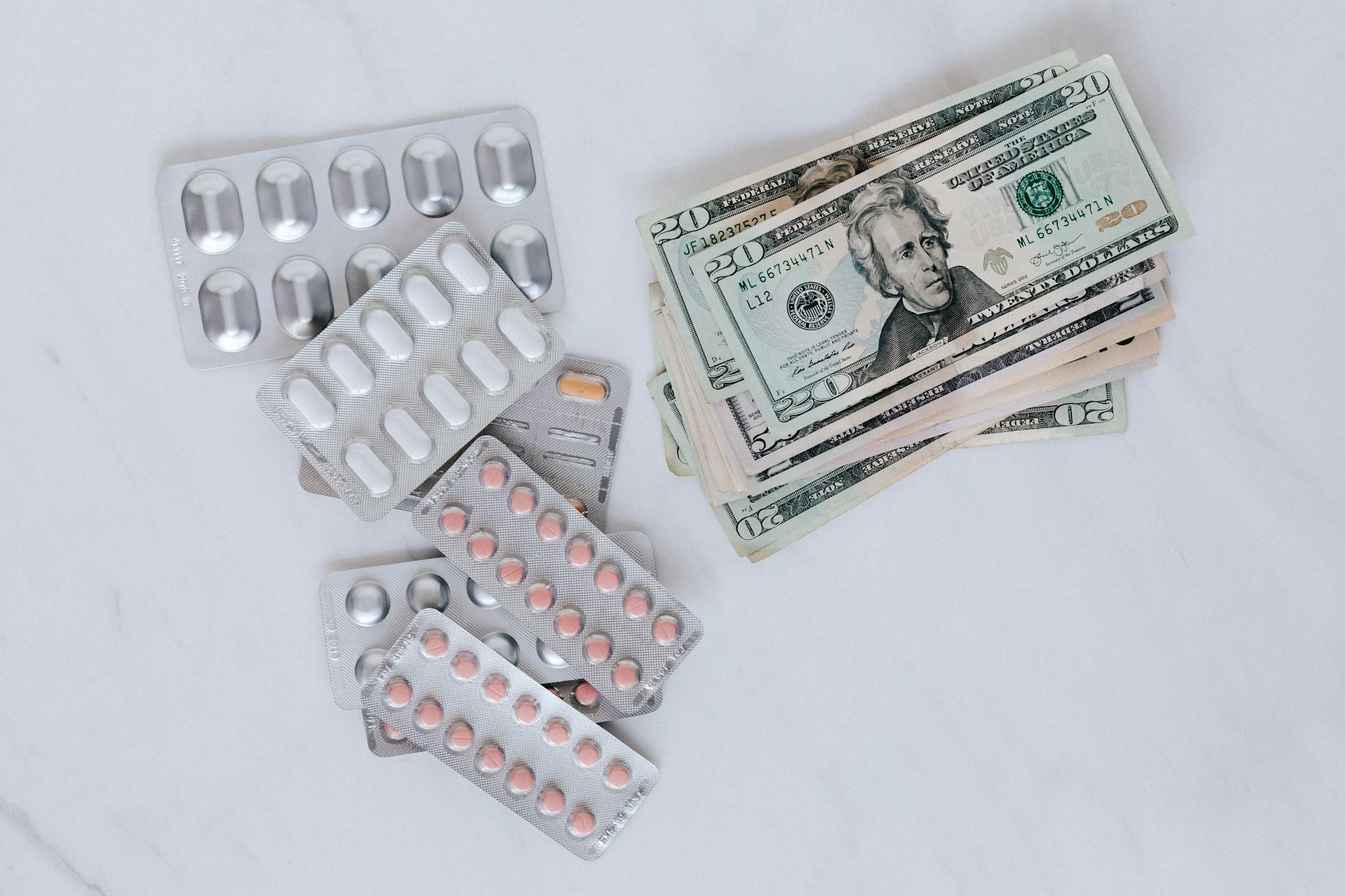 Set of pills with heap of paper money