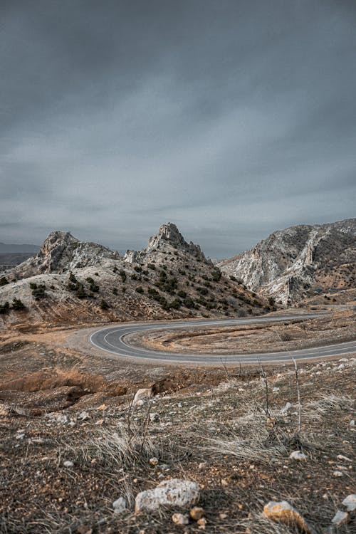 Asphalt road through mountainous stony valley