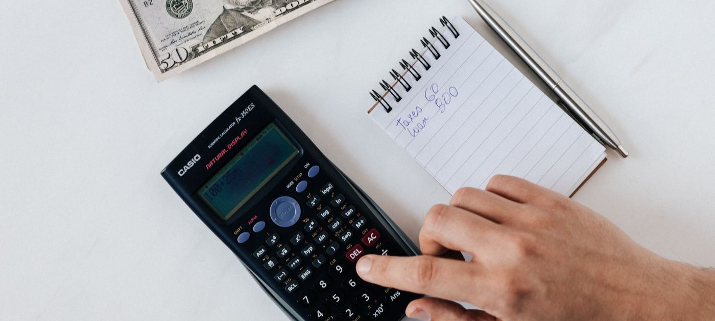 A calculator and banknotes on a desk — working out the real cost of termite treatment in Selangor