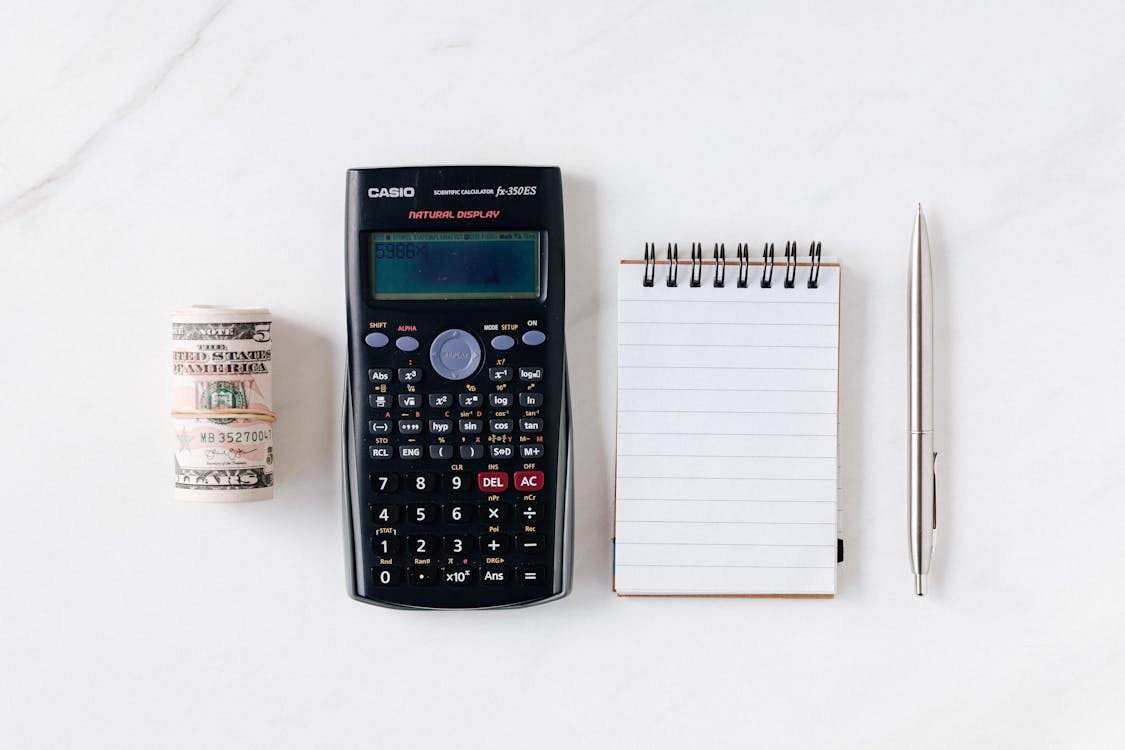 Free Composition of calculator with paper money and notebook with pen Stock Photo comprehensive income