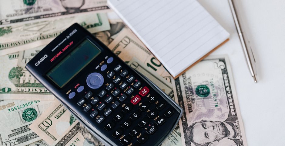 A calculator resting on banknotes — working out the full pest control price list for Malaysia in 2026