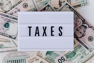 Reviewing and paying bills on time with taxes and dollar bills