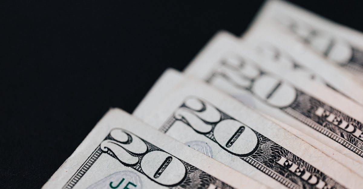 Photo by Karola G Closeup of USA 20 dollar bills placed on black surface as national currency for business and personal financial operations