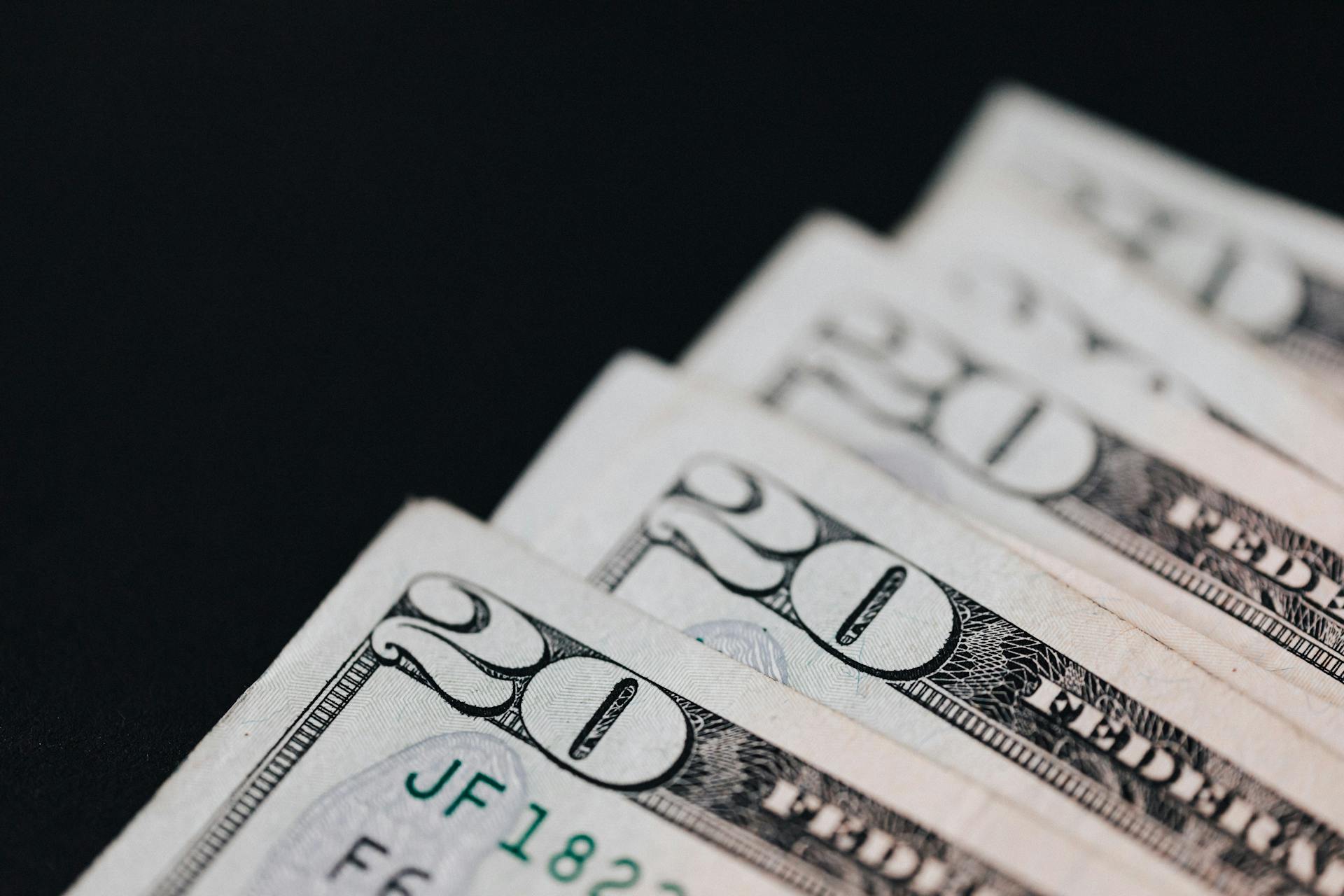 Closeup of USA 20 dollar bills placed on black surface as national currency for business and personal financial operations