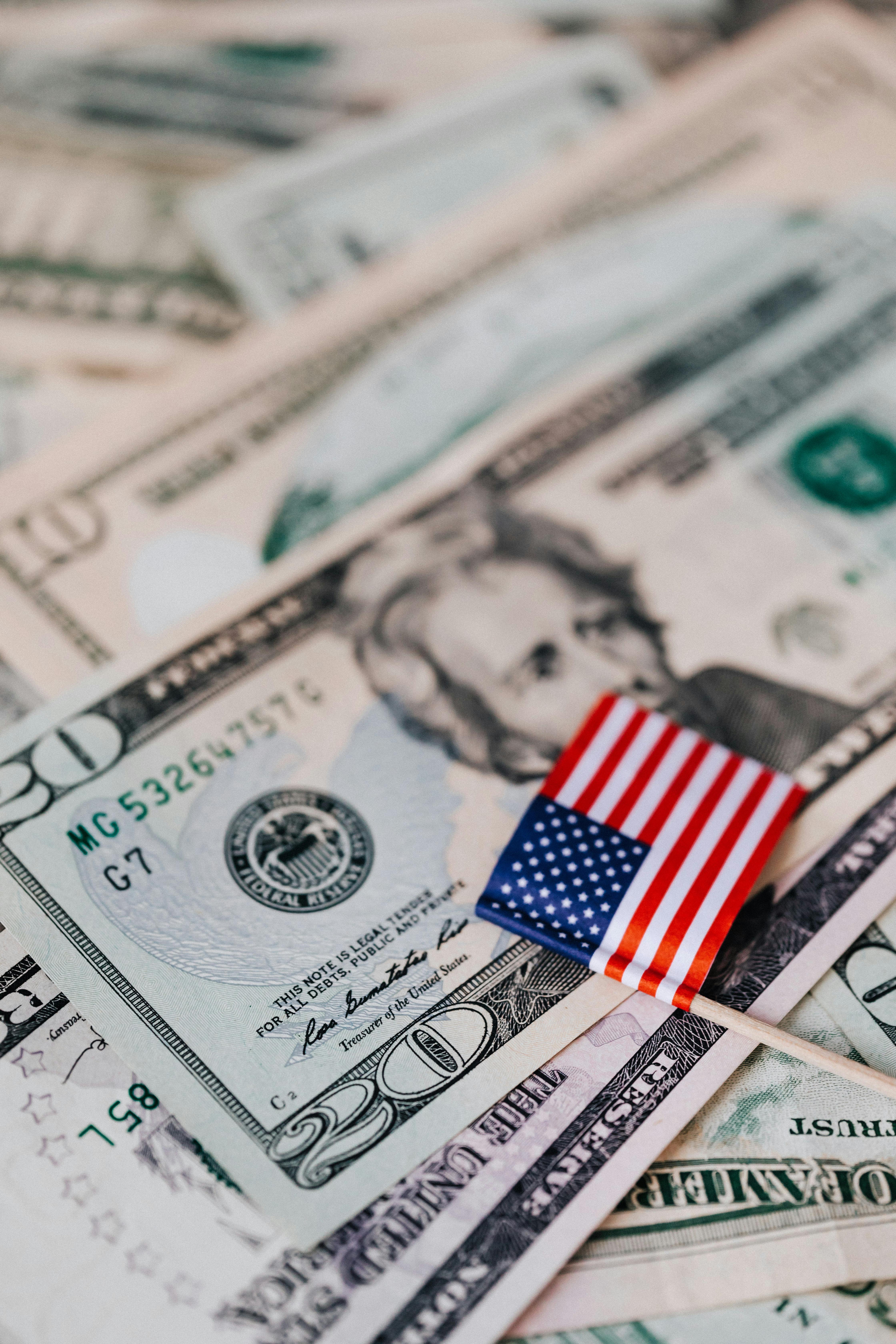 stack of usa money and national flag