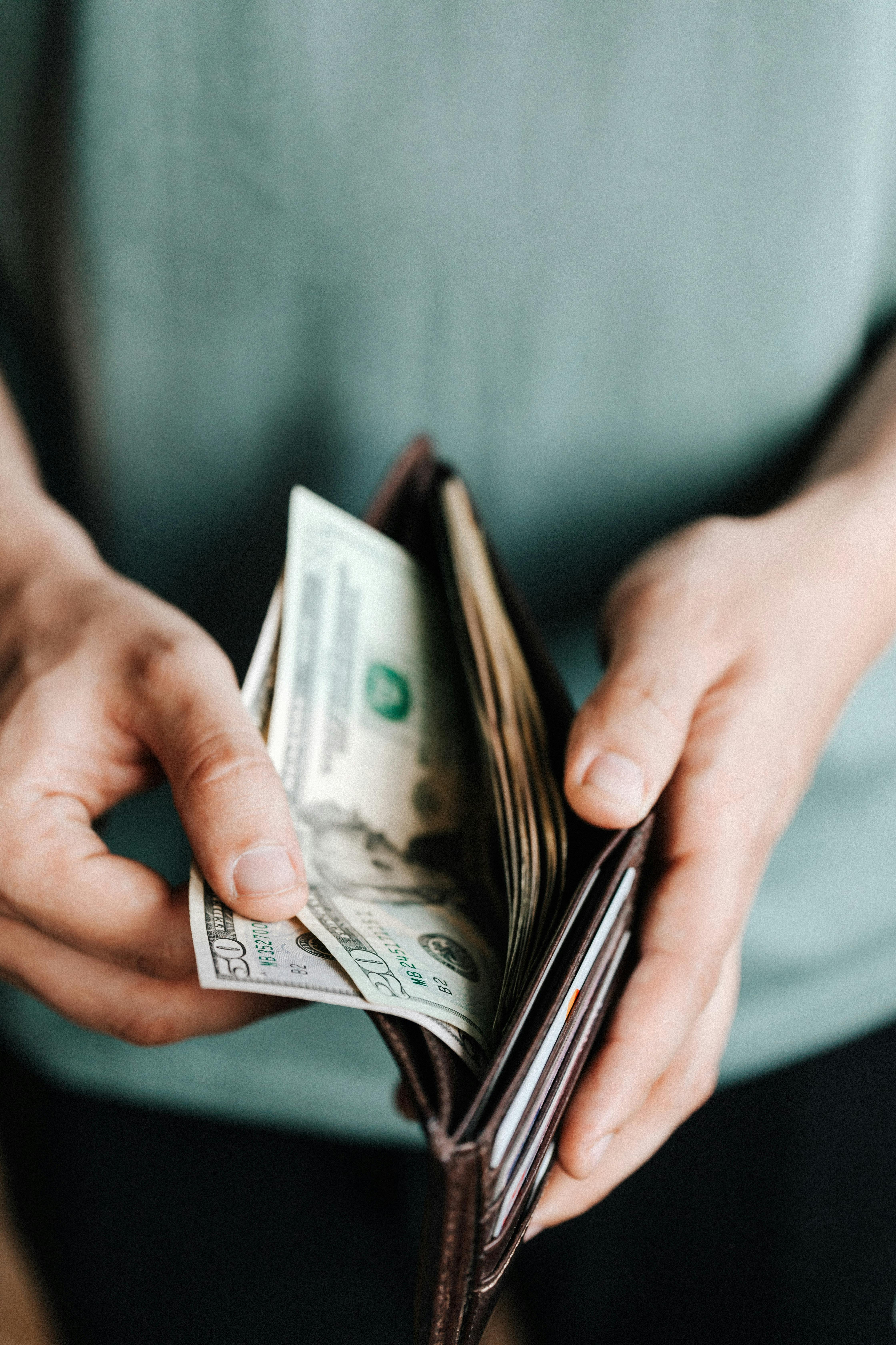 Person getting dollars from a wallet. | Photo: Pexels