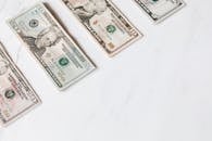 干净的白色表面上排列着不同面额的美元纸币