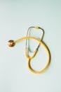 Top view of yellow medical stethoscope placed on white surface during coronavirus pandemic