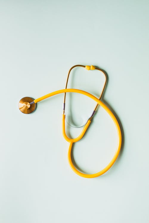 Free Top view of yellow medical stethoscope placed on white surface during coronavirus pandemic Stock Photo