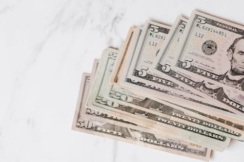 Free Different dollar bills on marble surface Stock Photo