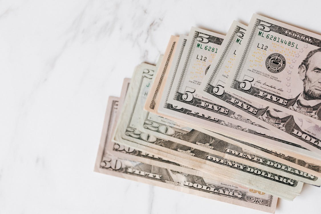 Free Different dollar bills on marble surface Stock Photo