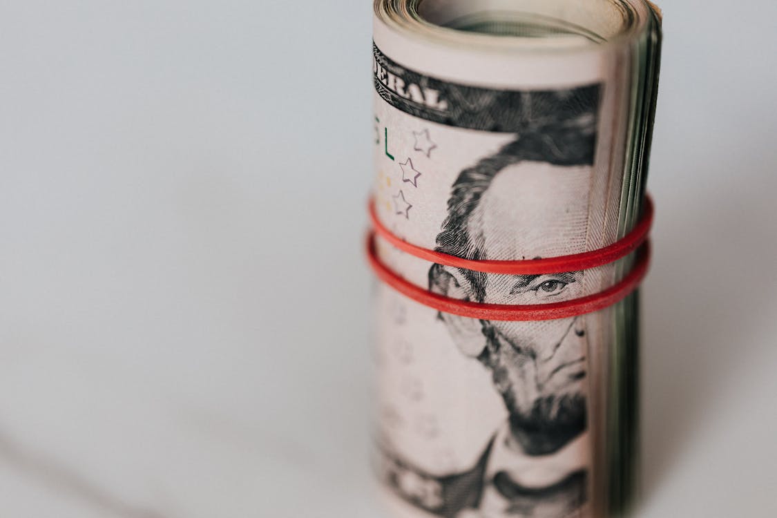 Free Roll of american dollars tightened with red band Stock Photo