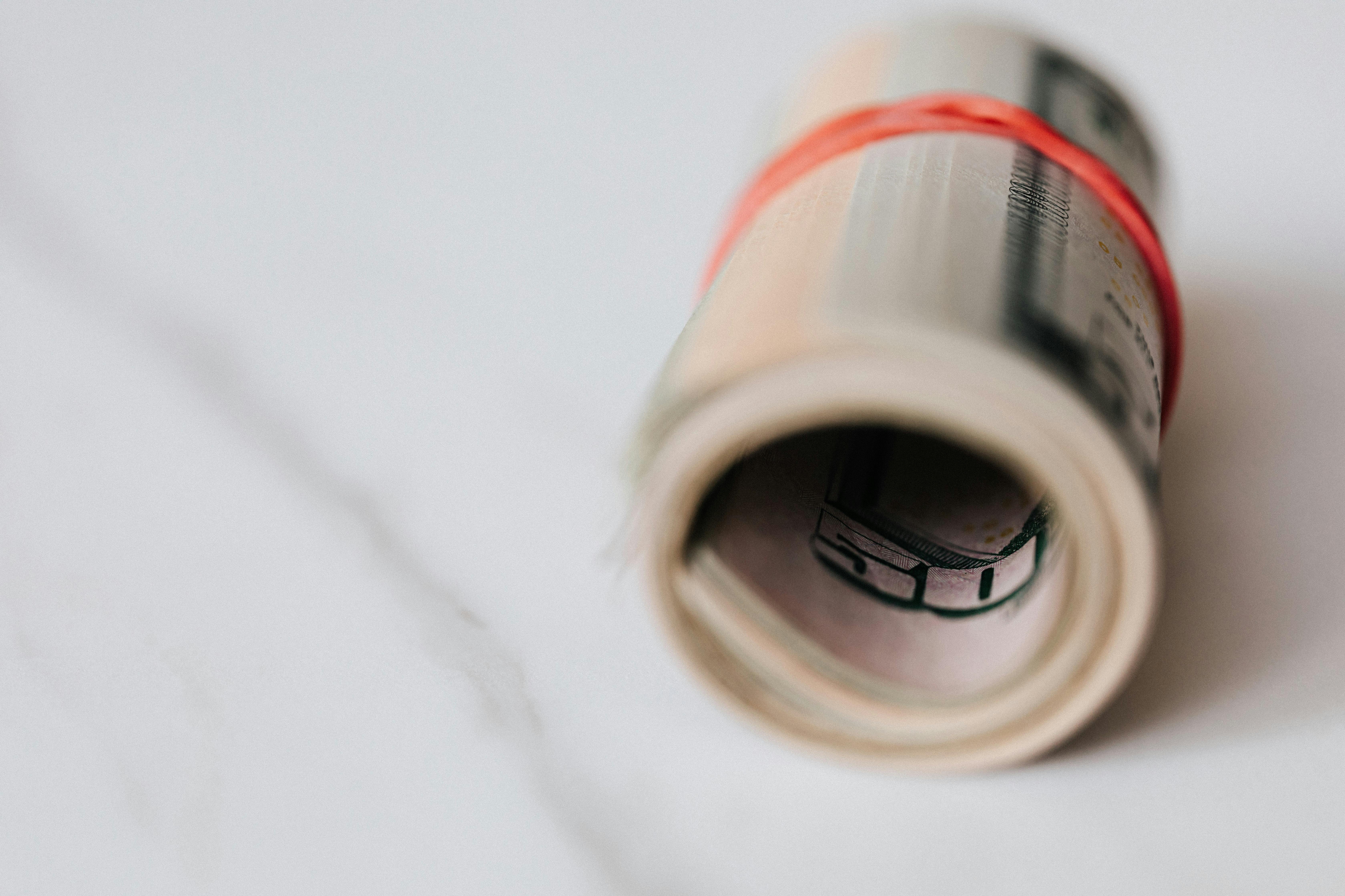 american dollar banknotes rolled and tightened with red band