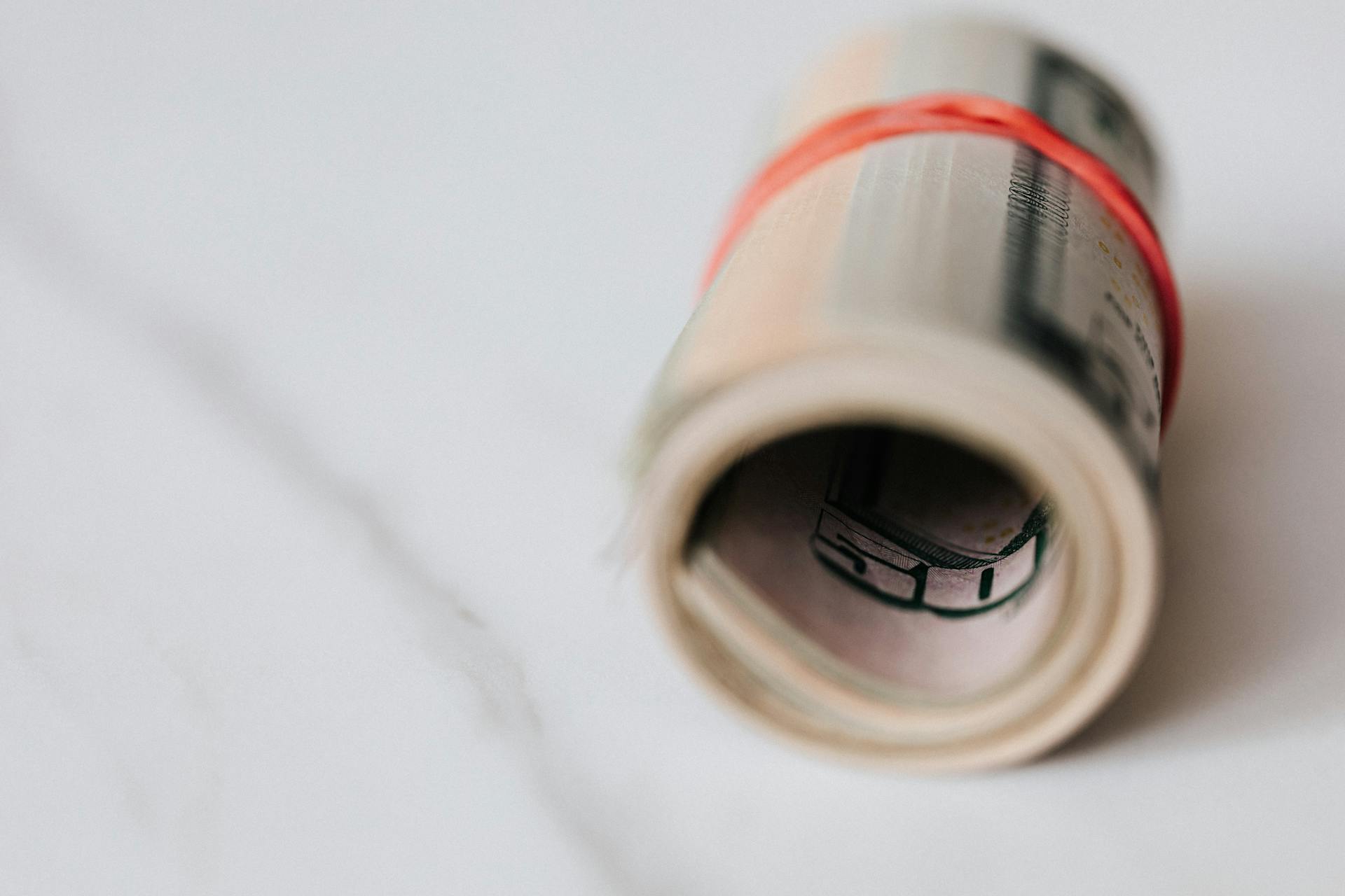 American dollar banknotes rolled and tightened with red band