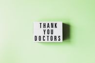 Top view of retro light box with THANK YOU DOCTORS inscription placed on green surface