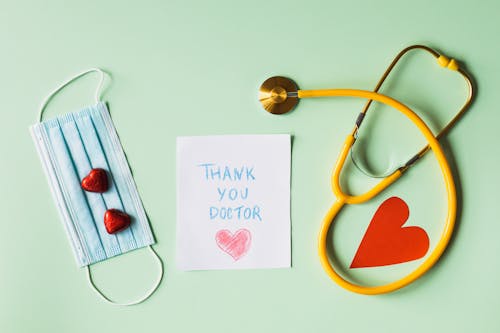Free Thank you Doctor Note next to a Face Mask and a Stethoscope Stock Photo