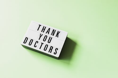 Free From above of vintage light box with THANK YOU DOCTORS inscription placed on green surface Stock Photo