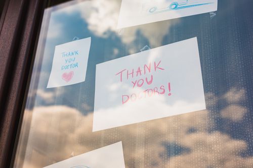 Free Handwritten thank you notes to doctors taped on a window, reflecting gratitude in challenging times. Stock Photo