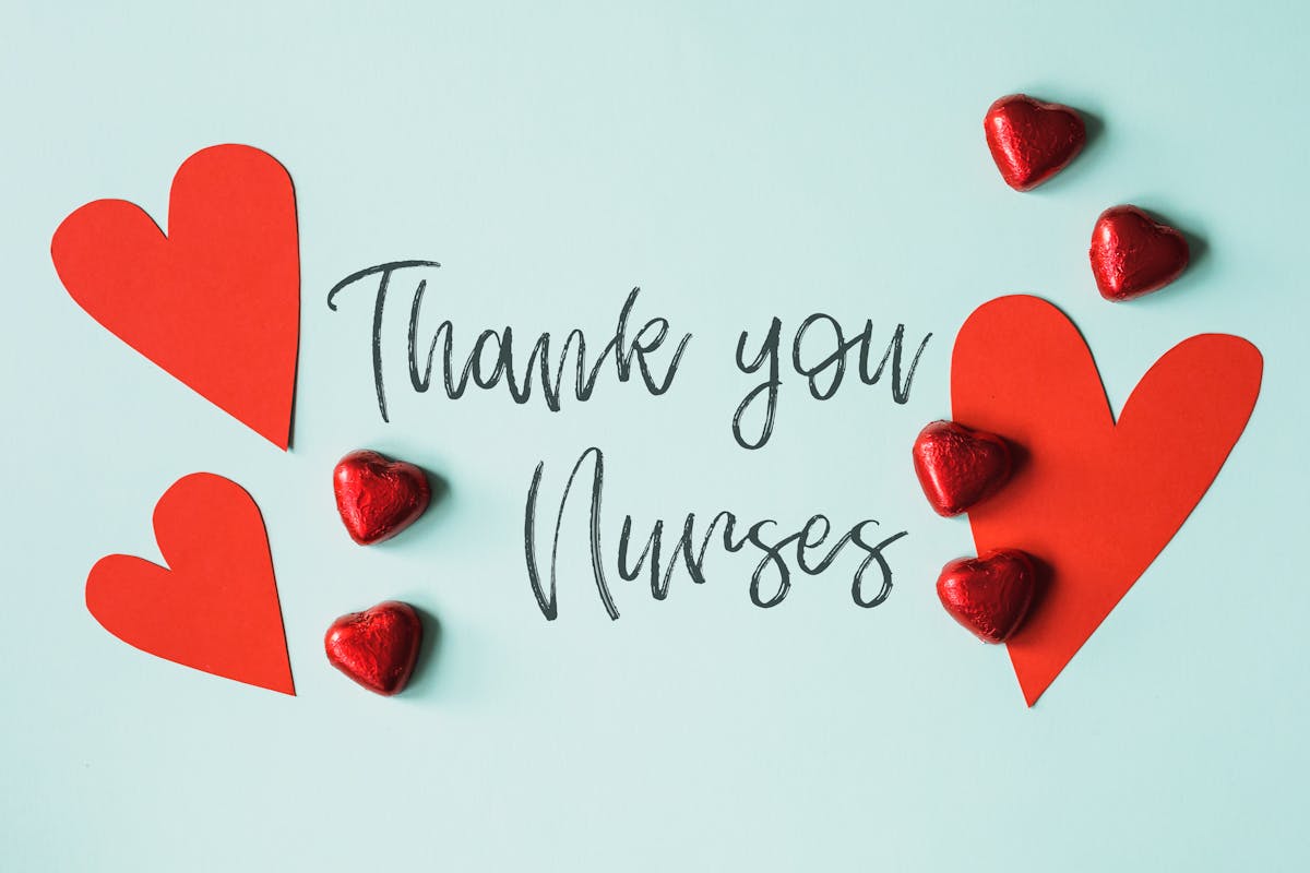 From above arrangement of red heart shapes placed on blue background with THANK YOU NURSES inscription