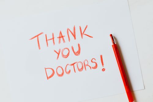 Free A heartfelt handwritten 'Thank You Doctors' note in red on white paper with a matching red pencil. Stock Photo