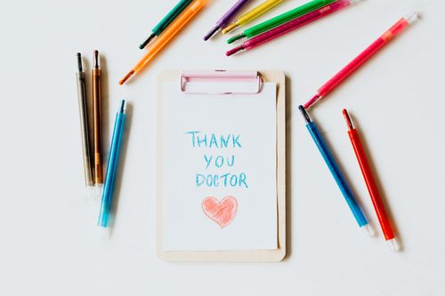 Free Creative thank you note for doctors on clipboard with pens symbolizing appreciation and gratitude. Stock Photo