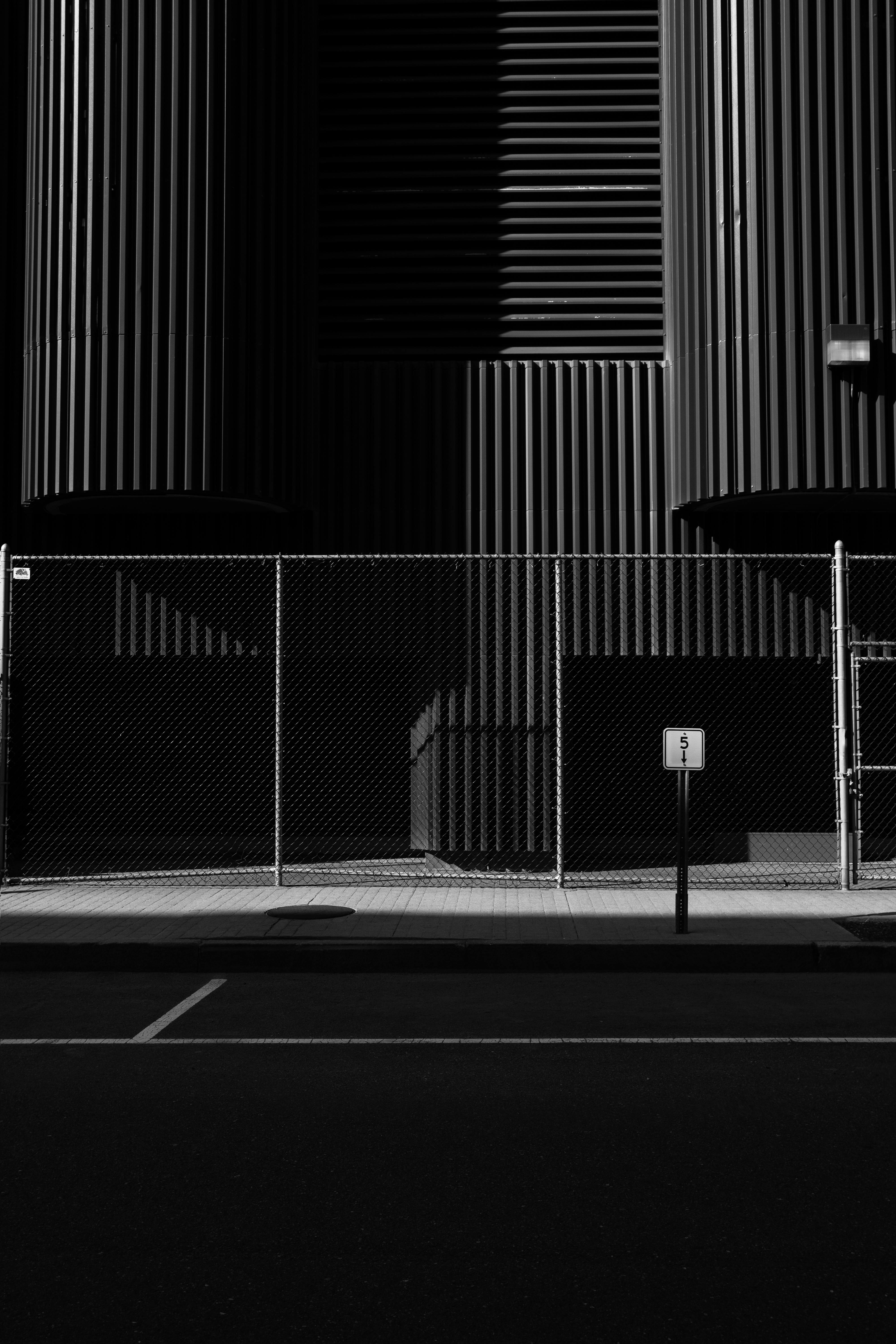 grayscale photo of chain link fence near the building