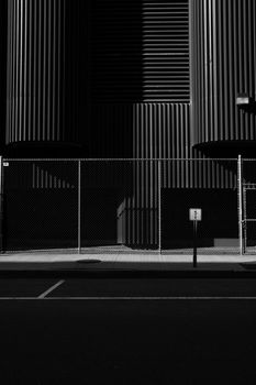 Black and white photo of industrial architecture with chain link fence in Cambridge, MA.