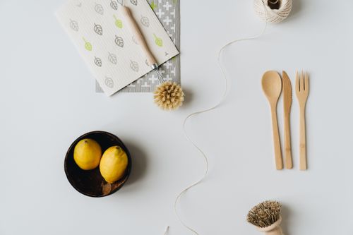 Free Minimalist arrangement of eco-friendly utensils, lemons, and cleaning tools on white background. Stock Photo