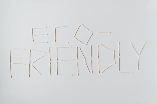 Cotton swabs spelling out "eco-friendly" on a clean white surface.
