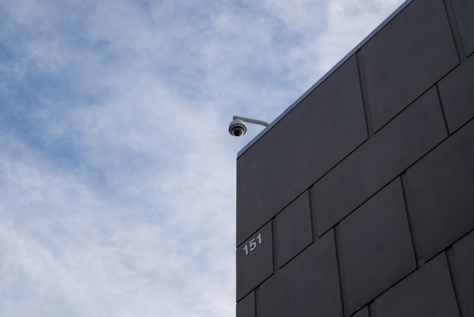 How Personal Capital Solves Net Worth Tracking for Busy Professionals A modern building facade with a security camera against a cloudy sky in Fort Worth, TX.