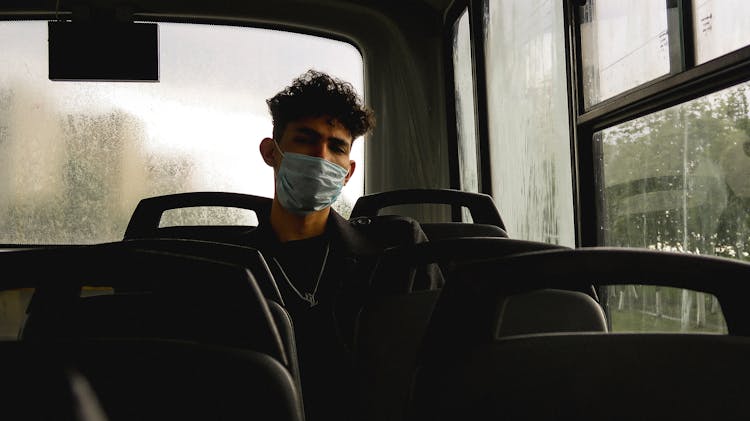 Serious Young Man In Protective Mask In Bus