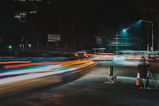 Vivid light trails capturing fast-paced urban night traffic in a bustling city street.