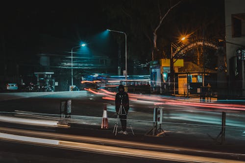 Man in Black Jacket Standing on Street during Night Time