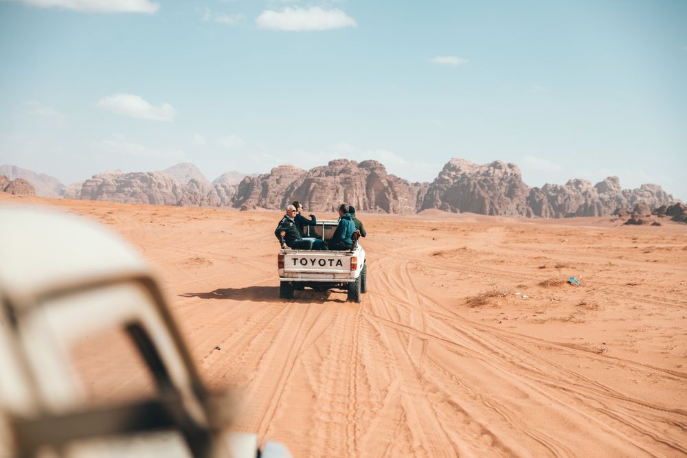 Vehículo 4x4 recorriendo las arenas rosadas del desierto de Wadi Rum