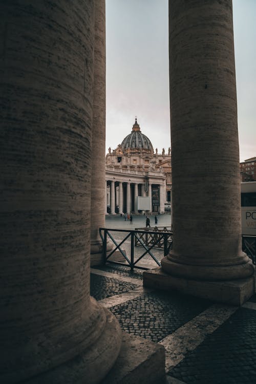 Weathered stone columns located near square with renaissance Cathedral of Saint Paul in Vatican