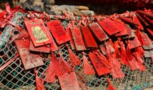 特写镜头捕捉到了悬挂在户外的红色木制护身符，展现了中国文化传统的精髓