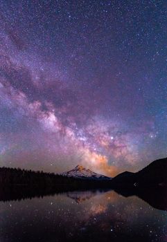 在宁静的湖面上，山峰倒映着灿烂的星夜，构成一幅神奇的景象