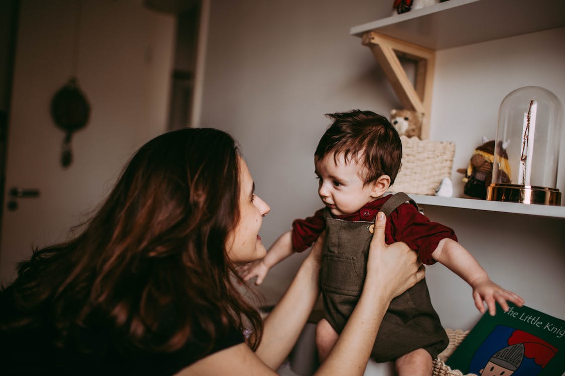 Free Smiling woman talking to little boy at home Stock Photo