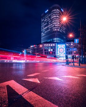 Vibrant night cityscape in Warsaw with light trails and illuminated buildings.