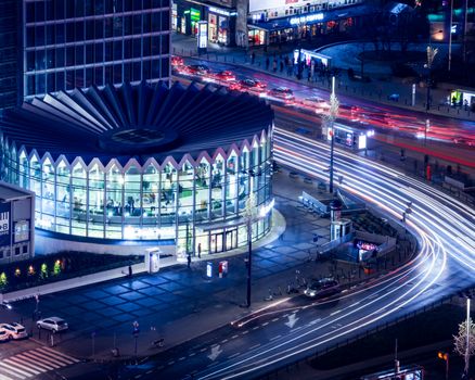 Dynamic cityscape of Warsaw with light trails and modern architecture at night.