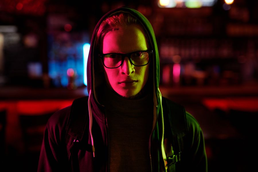 Hombre con hoodie bajo luces urbanas