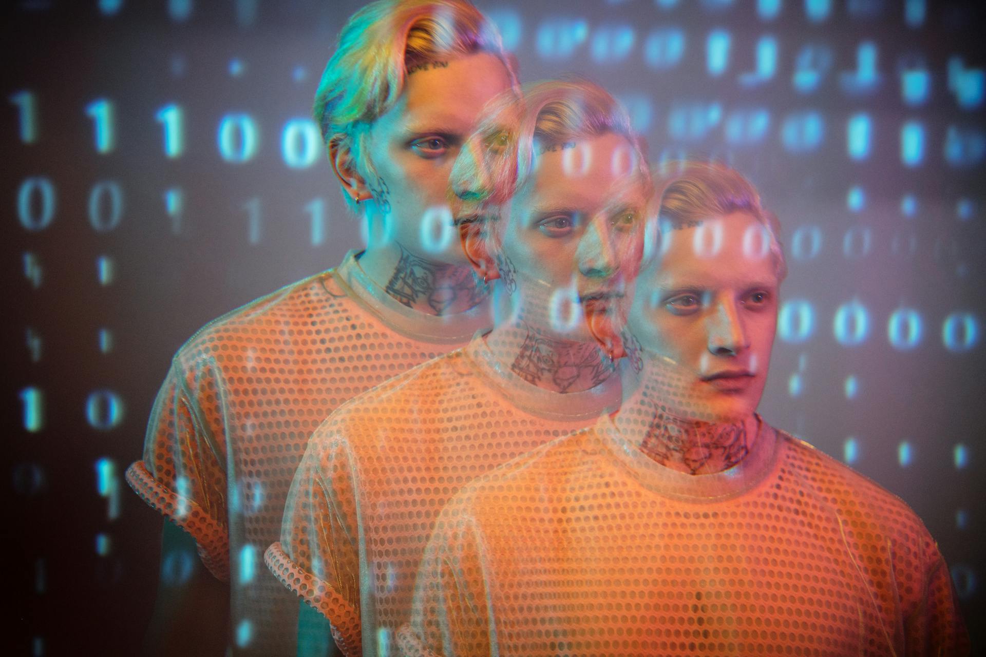 Multi-exposure portrait of a man with binary code overlay, creating a futuristic, digital aesthetic.