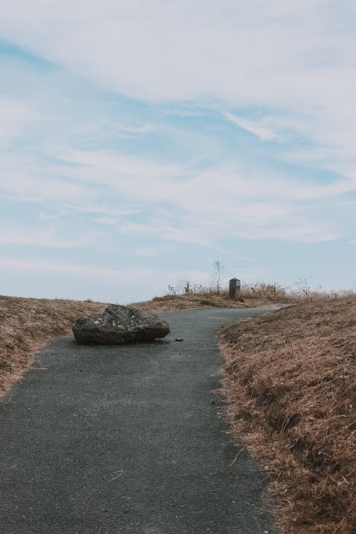 Free Empty pathway with rough stone under cloudy sky Stock Photo
