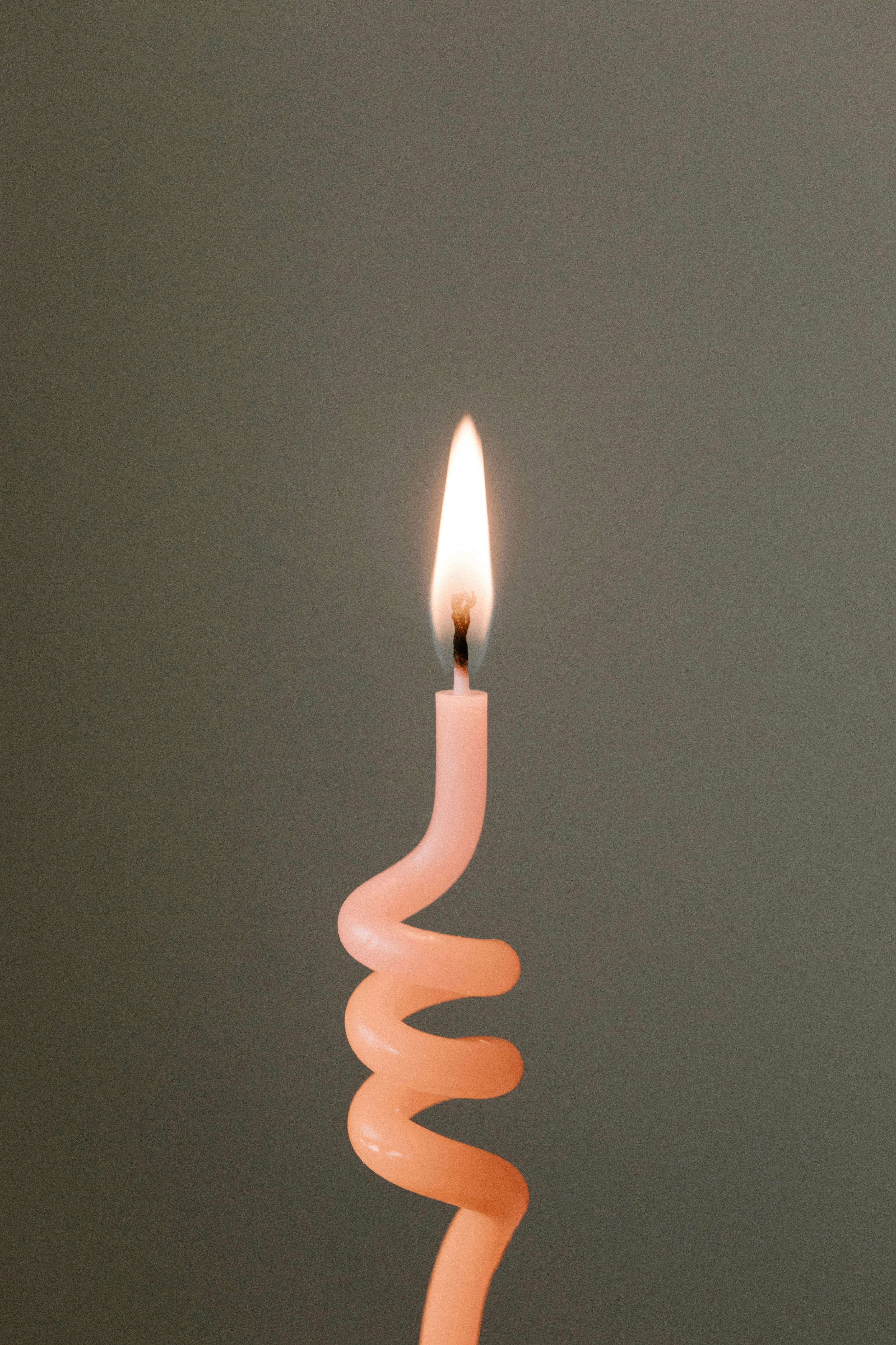 Burning pink candle against gray background · Free Stock Photo